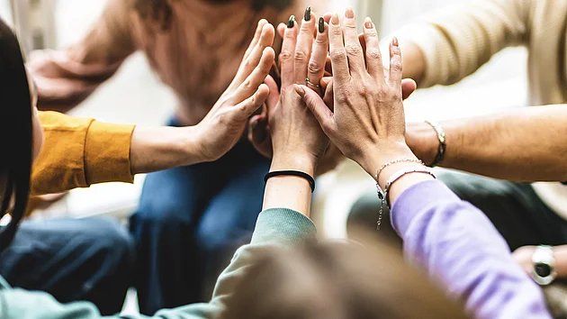 Young multiracial group stacking hands together- Happy diverse friends united at community table having fun- youth Millennial students giving strength motivation- Human resources teamwork concept